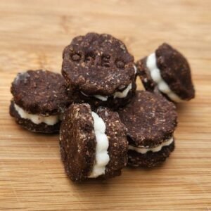 a pile of brown and white sandwich cookies on a wooden table with oreo stamped into the cookies