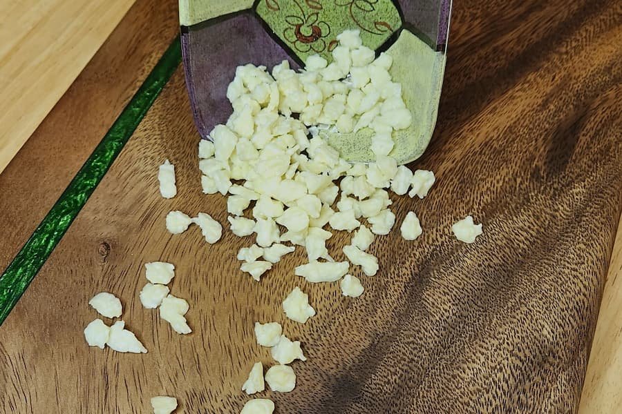 Dehydrated yogurt coconut drops spilling out of a bowl